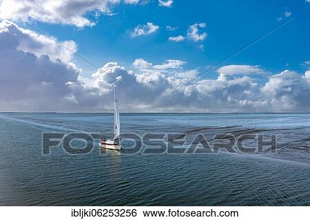 Sailing boat entering the harbour, Benser Außentief, Bensersiel, Lower Saxony, Germany, Europe View Large Photo Image Stock Photograph - Sailing boat entering the harbour, Benser Außentief, Bensersiel, Lower Saxony, Germany, Europe. Fotosearch
