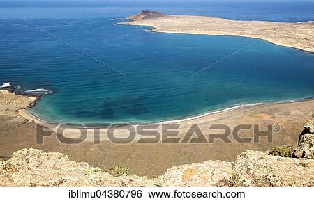 Sandy beach, view from El Rio channel to southern tip of Graciosa Island, Lanzarote, Canary Islands, Spain, Europe View Large Photo Image Stock Photograph - Sandy beach, view from El Rio channel to southern tip of Graciosa Island, Lanzarote, Canary Islands, Spain, Europe. Fotosearch