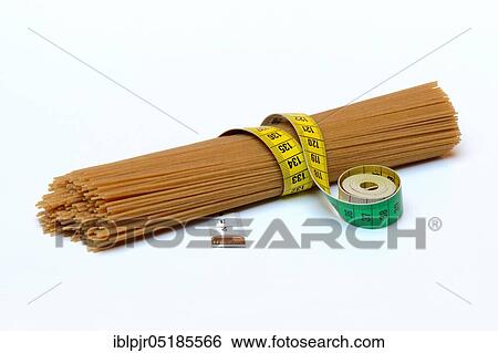 Stock Photograph - Spaghettis with measuring tape, wholemeal spaghetti. Fotosearch