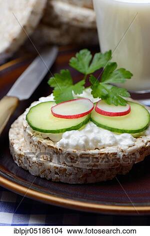 Spelt wafer topped with cream cheese, cucumber and radish, glass of milk, spelt wafers View Large Photo Image Picture - Spelt wafer topped with cream cheese, cucumber and radish, glass of milk, spelt wafers. Fotosearch