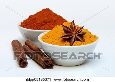 Stock Image - Spices in bowls, Turmeric ( Curcuma longa) turmeric, paprika, chili, star anise, sticks ( Cinnamomum spec. ). Fotosearch