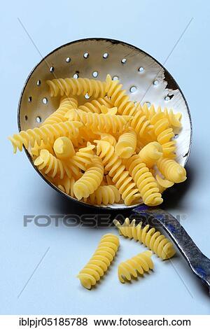 Spiral noodles in sieve ladle, Fusilli, uncooked View Large Photo Image Stock Photo - Spiral noodles in sieve ladle, Fusilli, uncooked. Fotosearch