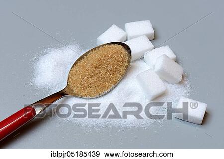 Stock Photo - Spoon with cane sugar and white sugar, sugar cubes, brown sugar, beet sugar, sugar crystals, household sugar. Fotosearch