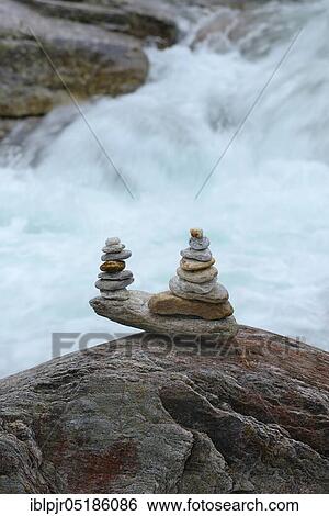 Stock Photograph - Stacked stones in front of running water, Valle Verzasca, Ticino, Switzerland, Europe. Fotosearch