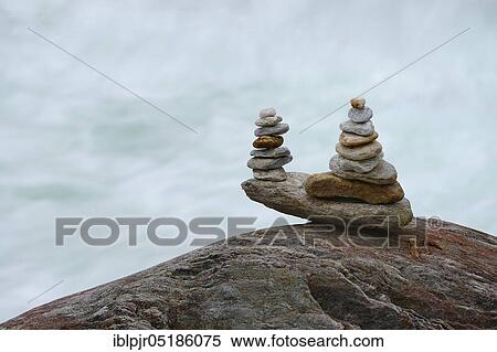 Stock Photography - Stacked stones in front of running water, Valle Verzasca, Ticino, Switzerland, Europe. Fotosearch