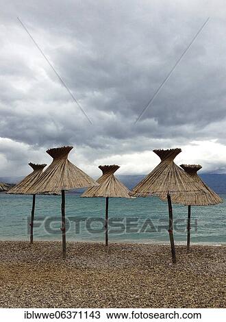 Straw parasols on the beach, bad weather, Baska, island of Krk, Kvarner Gulf bay, Adriatic Sea, Croatia, Europe View Large Photo Image Stock Image - Straw parasols on the beach, bad weather, Baska, island of Krk, Kvarner Gulf bay, Adriatic Sea, Croatia, Europe. Fotosearch