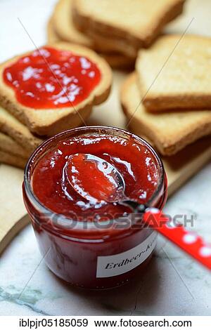 Stock Photo - Strawberry jam in glass with spoon and rusk. Fotosearch