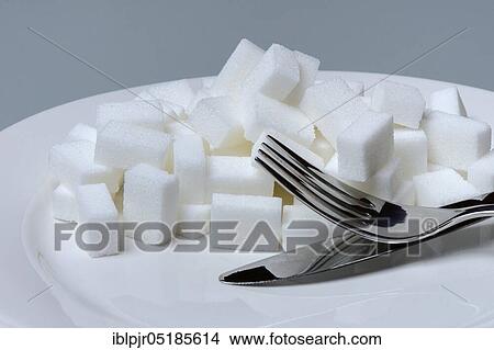 Picture - Sugar cubes on plate with cutlery, sugar consumption, sugar consumption. Fotosearch