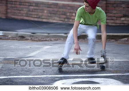 Teenager riding a longboard on a wet street View Large Photo Image Stock Photograph - Teenager riding a longboard on a wet street. Fotosearch