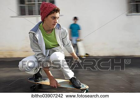 Teenager riding a longboard View Large Photo Image Stock Image - Teenager riding a longboard. Fotosearch