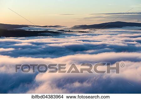 Thick fog is filling the valley of the river Elbe in Elbsandsteingebirge, seen from Lilienstein at sunrise, Königstein, Saxony, Germany, Europe View Large Photo Image Picture - Thick fog is filling the valley of the river Elbe in Elbsandsteingebirge, seen from Lilienstein at sunrise, Königstein, Saxony, Germany, Europe. Fotosearch