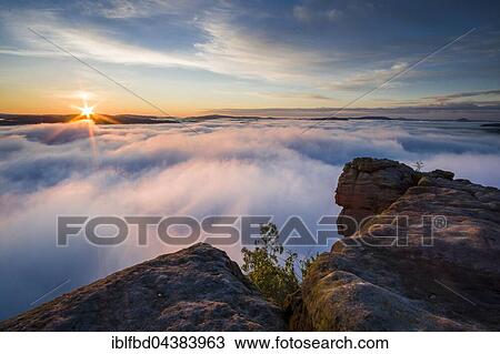 Thick fog is filling the valley of the river Elbe in Elbsandsteingebirge, seen from Lilienstein at sunrise, Königstein, Saxony, Germany, Europe View Large Photo Image Stock Image - Thick fog is filling the valley of the river Elbe in Elbsandsteingebirge, seen from Lilienstein at sunrise, Königstein, Saxony, Germany, Europe. Fotosearch