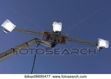 Three spotlights in front of a blue sky, mounted on a working stage, Filmlicht, Düsseldorf, North Rhine-Westphalia, Germany, Europe View Large Photo Image Stock Photo - Three spotlights in front of a blue sky, mounted on a working stage, Filmlicht, Düsseldorf, North Rhine-Westphalia, Germany, Europe. Fotosearch