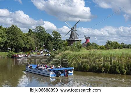 Tourist boat on the Old Greetsiel Sieltief, in the background the twin mills, Greetsiel, Lower Saxony, Germany, Europe View Large Photo Image Stock Image - Tourist boat on the Old Greetsiel Sieltief, in the background the twin mills, Greetsiel, Lower Saxony, Germany, Europe. Fotosearch