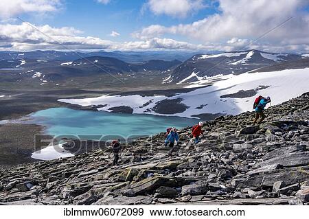 Stock Photo - Tundra, barren mountain landscape with mountain lake, Hiker on hike to Snøhetta mountain, Dovrefjell National Park, Oppdal, Norway, Europe. Fotosearch