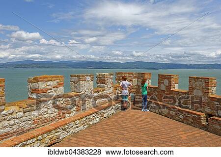 Two children stand on battlements, Fortezza, Rocca del Leone, Castiglione del Lago, on Lake Trasimeno, Lago Trasimeno, Umbria, Italy, Europe View Large Photo Image Stock Photo - Two children stand on battlements, Fortezza, Rocca del Leone, Castiglione del Lago, on Lake Trasimeno, Lago Trasimeno, Umbria, Italy, Europe. Fotosearch