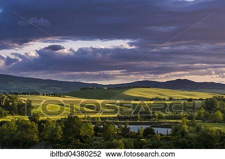 Typical green Tuscan landscape in Val d’Orcia with hills, a lake, trees, fields and Monte Amiata in the distance at sunset, Spedaletto, Tuscany, Italy, Europe View Large Photo Image Stock Image - Typical green Tuscan landscape in Val d’Orcia with hills, a lake, trees, fields and Monte Amiata in the distance at sunset, Spedaletto, Tuscany, Italy, Europe. Fotosearch