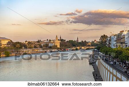 View over the river Rio Guadalquivir with promenade at Calle Betis in Triana and Torre del Oro, sunset, Sevilla, Andalusia, Spain, Europe View Large Photo Image Picture - View over the river Rio Guadalquivir with promenade at Calle Betis in Triana and Torre del Oro, sunset, Sevilla, Andalusia, Spain, Europe. Fotosearch
