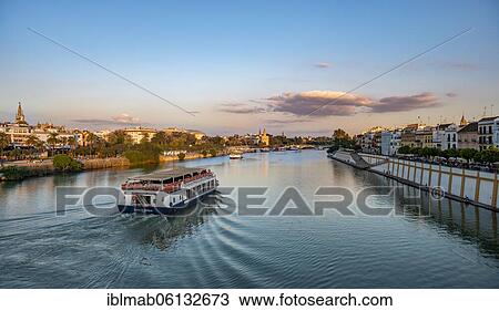 View over the river Rio Guadalquivir with excursion boats, promenade on Calle Betis in Triana and view of Torre del Oro, sunset, Sevilla, Andalusia, Spain, Europe View Large Photo Image Stock Image - View over the river Rio Guadalquivir with excursion boats, promenade on Calle Betis in Triana and view of Torre del Oro, sunset, Sevilla, Andalusia, Spain, Europe. Fotosearch