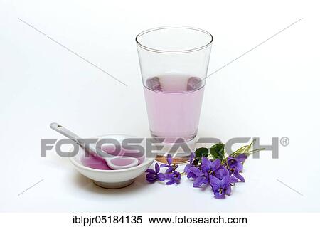 Stock Photography - Violet syrup in bowl and glass, violet flowers. Fotosearch