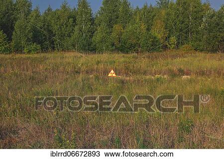 Warning sign against radioactive radiation in meadow, Chernobyl exclusion zone, Ukraine, Europe View Large Photo Image Stock Image - Warning sign against radioactive radiation in meadow, Chernobyl exclusion zone, Ukraine, Europe. Fotosearch