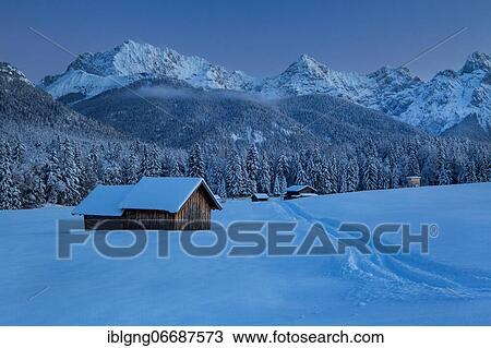 Stock Image - Winterly hummock meadows with hay barn and Karwendel mountains at dusk, Krün, Werdenfelser Land, Upper Bavaria, Bavaria, Germany, Europe. Fotosearch
