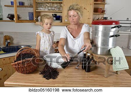 Woman and girl cooking elderberry juice (Sambucus nigra) (Sambuci fructus) View Large Photo Image Stock Photo - Woman and girl cooking elderberry juice (Sambucus nigra) (Sambuci fructus). Fotosearch