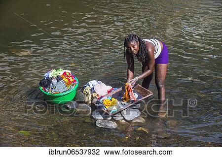 Stock Image - Woman washing her clothes in a river at the east coast of Sao Tome, Sao Tome and Principe, Atlantic Ocean, Africa. Fotosearch