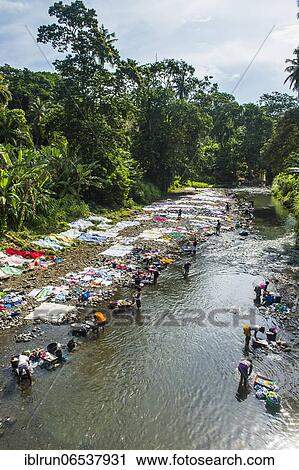 Stock Image - Women washing their clothes in a river at the east coast of Sao Tome, Sao Tome and Principe, Atlantic Ocean, Africa. Fotosearch