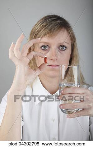 Stock Photography - Young woman taking a capsule, Medicine. Fotosearch