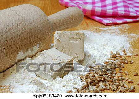 Stock Image - Baker's yeast, yeast, yeast cubes and wheat flour, wheat grains, flour, baking ingredient, baking agent, dry yeast. Fotosearch