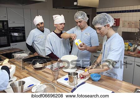Stock Photo - Baking in practical lessons in home economics, integration of refugees in the AVI class (Ausbildungsvorbereitung International) at the Elly-Heuss-Knapp-Schule, a vocational college of the city of Düsseldorf, North Rhine-Westphalia, Germany, Europe. Fotosearch