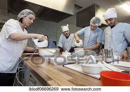 Stock Photo - Baking in practical lessons in home economics, integration of refugees in the AVI class (Ausbildungsvorbereitung International) at the Elly-Heuss-Knapp-Schule, a vocational college of the city of Düsseldorf, North Rhine-Westphalia, Germany, Europe. Fotosearch