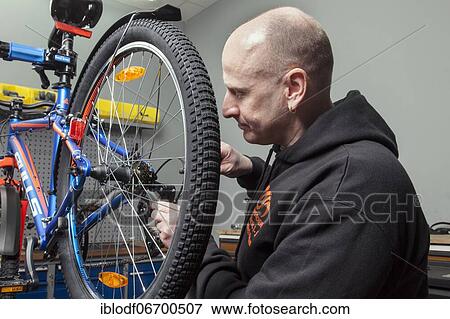Bike mechanic in the bike workshop during an inspection on a mountain bike, checking and adjusting the gears View Large Photo Image Stock Photo - Bike mechanic in the bike workshop during an inspection on a mountain bike, checking and adjusting the gears. Fotosearch
