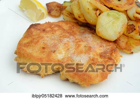 Stock Photo - Breaded schnitzel with fried potatoes. Fotosearch