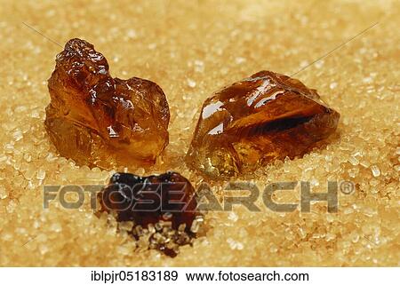 Stock Photo - Brown rock candy and brown cane sugar, sweet, sugar crystals, rock candy. Fotosearch