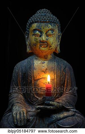 Stock Photo - Buddha with burning candle. Fotosearch