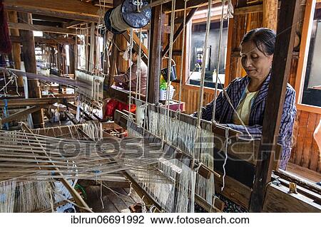 Stock Image - Burmese woman weaving lotus silk, Nampan village, Inle lake, Shan state, Myanmar, Asia. Fotosearch