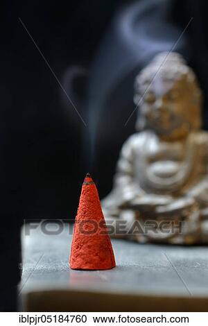 Stock Image - Burning incense cone with Buddha. Fotosearch