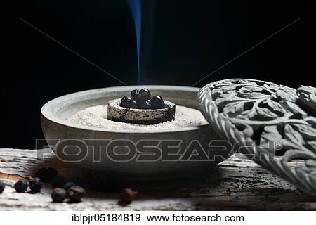 Stock Photo - Burning juniper berries ( Juniperus communis) in shell with sand. Fotosearch