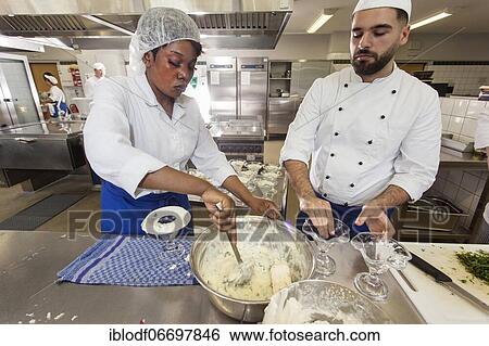 Stock Photograph - Canteen kitchen in a vocational college in Düsseldorf, trainees manage the school's catering as part of their training, practical lessons in the canteen's canteen kitchen, trainees portioning dessert, Düsseldorf, Germany, Europe. Fotosearch