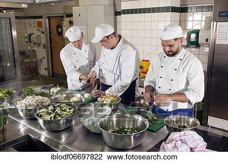 Canteen kitchen in a vocational college, trainees manage the catering of the school, chef and head of training shows the professional handling of the kitchen knife while cutting onions, Düsseldorf, Germany, Europe View Large Photo Image Stock Image - Canteen kitchen in a vocational college, trainees manage the catering of the school, chef and head of training shows the professional handling of the kitchen knife while cutting onions, Düsseldorf, Germany, Europe. Fotosearch