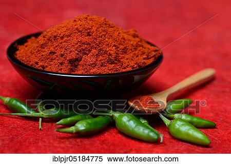 Stock Photography - ( Capsicum annuum) Chilli powder in bowl and spoon and green chillies, paprika powder, chillies, kitchen spice, peppers. Fotosearch