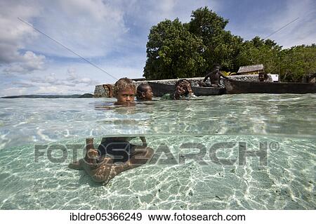 Stock Photo - Children playing in lagoon, Florida Islands, Solomon Islands, Oceania. Fotosearch