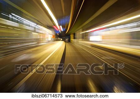Stock Image - Colorful, semi-abstract light traces from a moving suspension railway in the evening, Wuppertal, Bergisches Land, North Rhine-Westphalia, Germany, Europe. Fotosearch