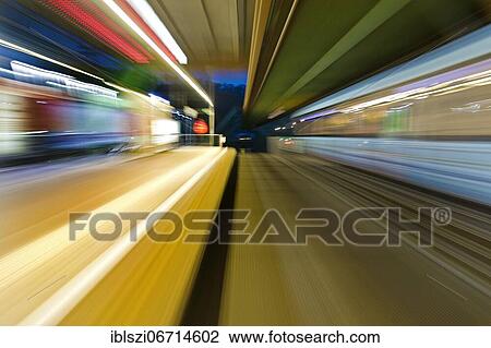 Stock Image - Colorful, semi-abstract light traces from a moving suspension railway in the evening, Wuppertal, Bergisches Land, North Rhine-Westphalia, Germany, Europe. Fotosearch