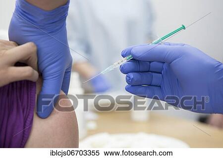 Stock Photography - Covid-19 vaccination, vaccine from AstraZeneca, syringe with vaccine on the upper arm, vaccination process, Bergisches Land, North Rhine-Westphalia, Germany, Europe. Fotosearch