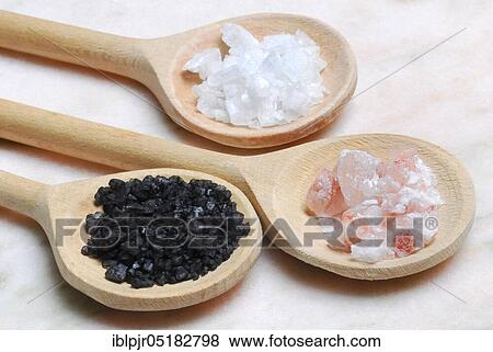 Stock Photo - Different kinds of salt on wooden spoons, crystal salt, Himalayan salt, Hawaiian salt, sodium chloride, table salt, salt crystals. Fotosearch