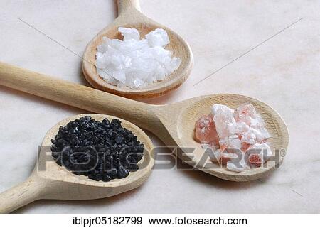 Stock Photo - Different kinds of salt on wooden spoons, crystal salt, Himalayan salt, Hawaiian salt, sodium chloride, table salt, salt crystals. Fotosearch