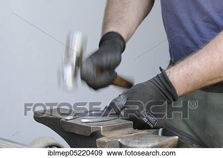 Stock Photo - Farrier at work, working on horseshoes, getting into shape. Fotosearch